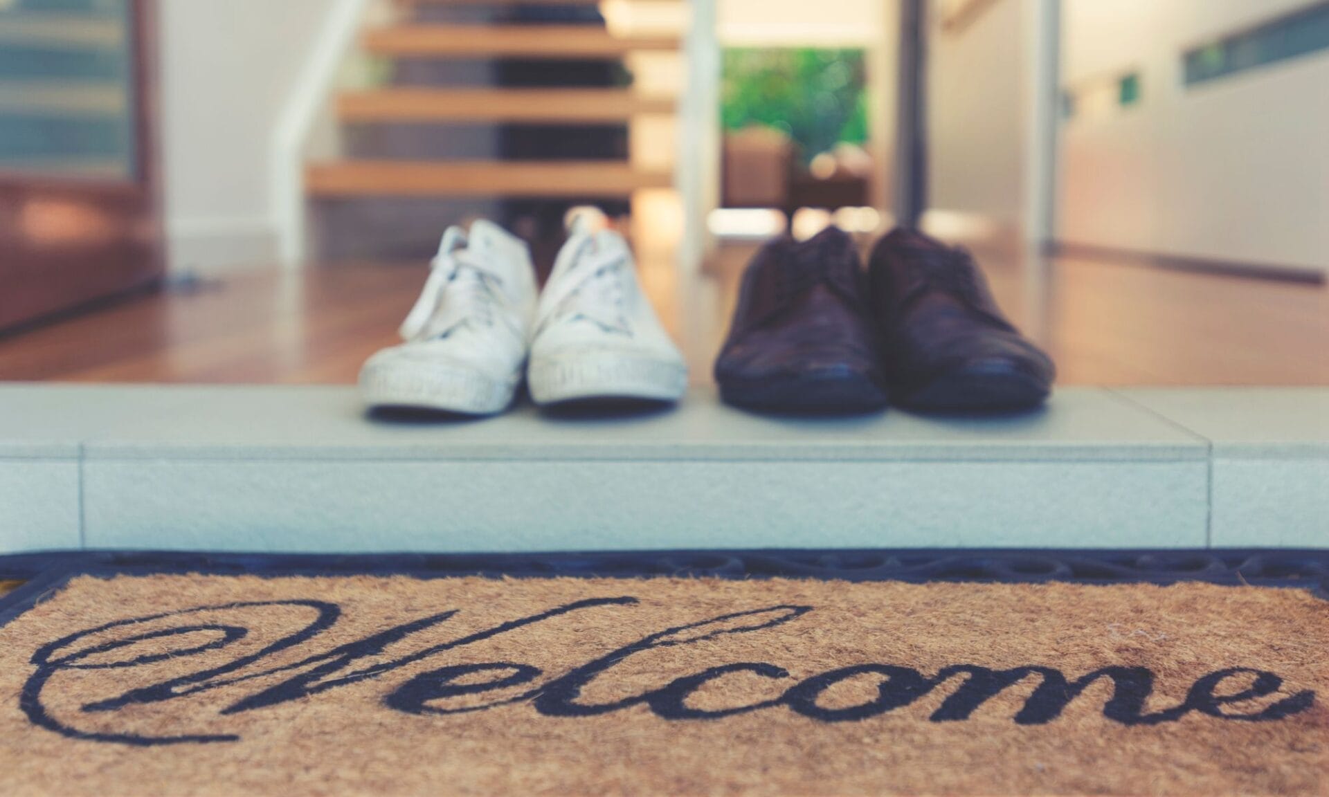 Shoes next to a welcome mat